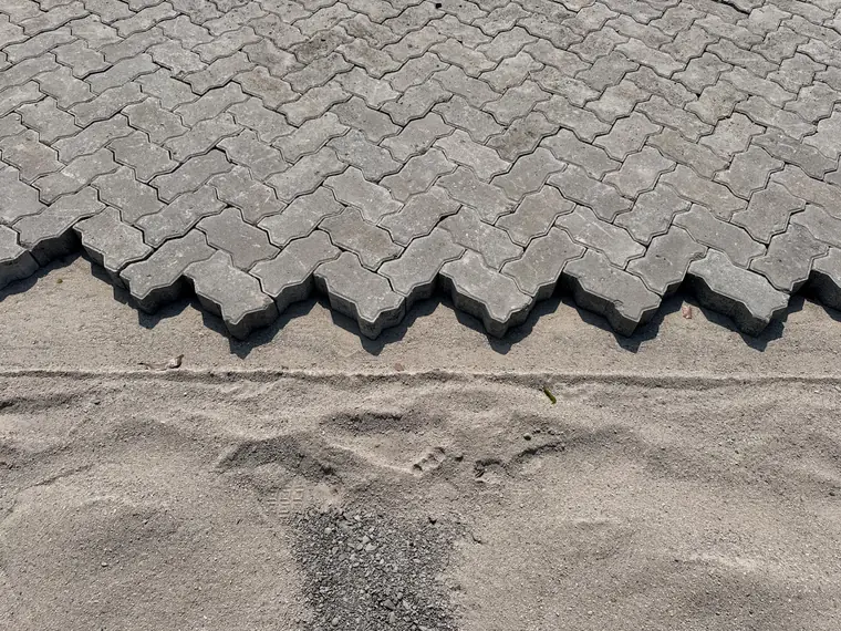 Detail tepi pemasangan paving block cacing K400 yang saling mengunci di atas pasir bedding